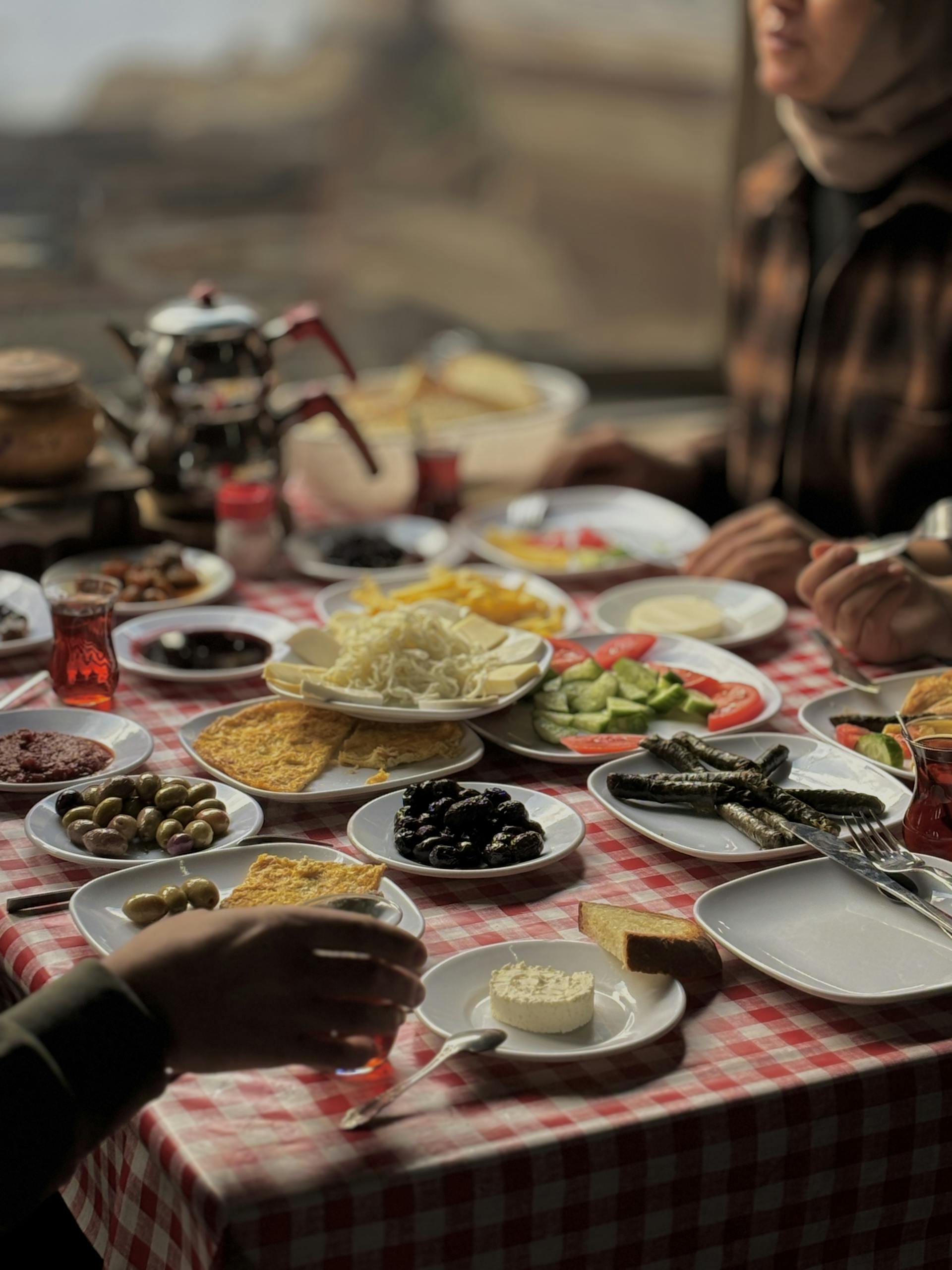 Delicious array of breakfast dishes on checkered table with teapot, ideal for food and lifestyle themes.